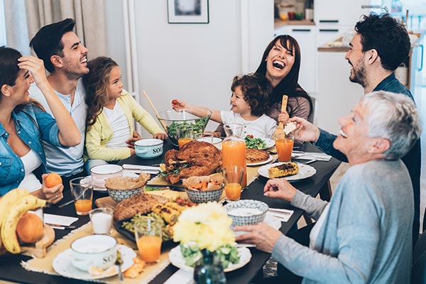 A large family laughing together over a dinner