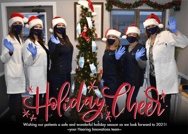 Hearing Innovations holiday card with the doctors and nurses wearing masks near a Christmas Tree